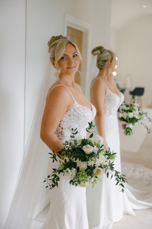 Bride with bouquet in mirror